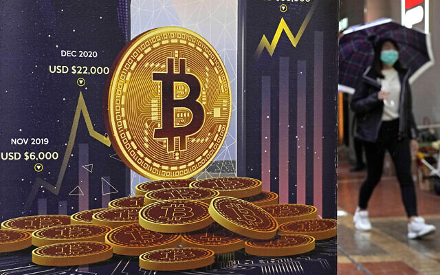 An advertisement for Bitcoin cryptocurrency is displayed on a street in Hong Kong, on Feb. 17, 2022.  Bitcoin slumped to a two-year low, Wednesday, Nov. 9, and other digital assets sold off following the sudden collapse of crypto exchange FTX Trading, which has been forced to sell itself to larger rival Binance. (AP Photo/Kin Cheung, File)