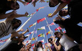 Fans cheer as they pose for a photograph at flag plaza in Doha, Qatar, November 11, 2022. (AP Photo/Hassan Ammar)