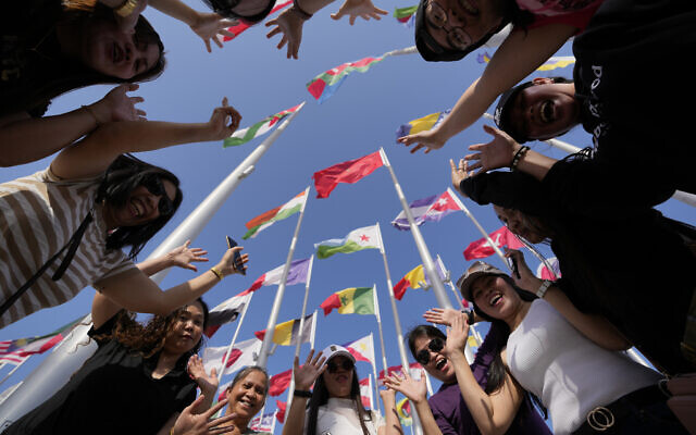 Fans cheer as they pose for a photograph at flag plaza in Doha, Qatar, November 11, 2022. (AP Photo/Hassan Ammar)