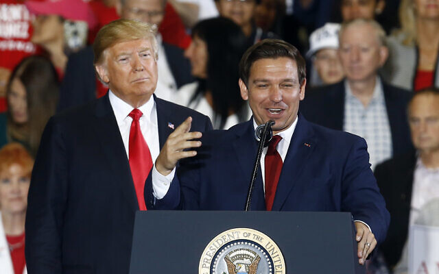 In this Nov. 3, 2018 file photo, US President Donald Trump stands behind gubernatorial candidate Ron DeSantis at a rally in Pensacola, Fla. (AP Photo/Butch Dill, File)