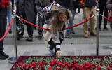 A woman leaves a flower at a memorial at the scene of Sunday's explosion on Istanbul's popular pedestrian Istiklal Avenue in Istanbul, Nov. 14, 2022 (AP Photo/Khalil Hamra)