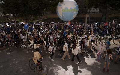 FILE - Activists participate in a climate march calling on the government to take action to reduce greenhouse gas emissions to limit the impact of climate change in Tel Aviv, Oct. 28, 2022. (AP Photo/Oded Balilty, File)
