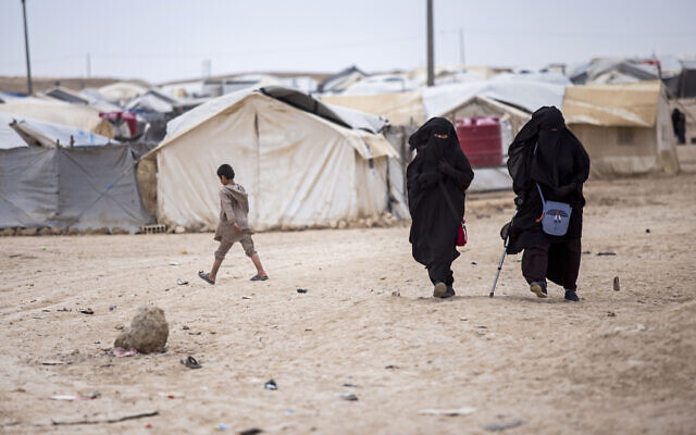 Women walk in the al-Hol camp that houses some 60,000 refugees, including families and supporters of the Islamic State group, many of them foreign nationals, in Hasakeh province, Syria, May 1, 2021. The Syrian Observatory for Human Rights and local officials said Tuesday, Nov. 15, 2022 that the beheaded bodies of two Egyptian girls were found Tuesday in a sprawling camp in northeastern Syria housing tens of thousands of women and children linked to the Islamic State group. (AP/Baderkhan Ahmad, File)