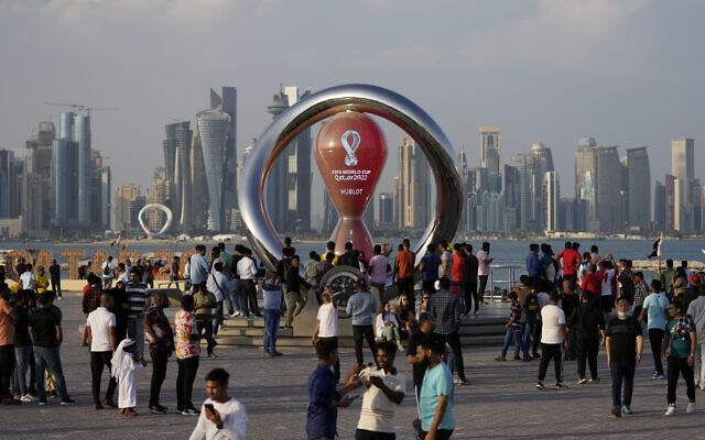 People gather around the official countdown clock showing remaining time until the kick-off of the World Cup in Doha, Qatar, November 11, 2022. (AP Photo/Hassan Ammar)