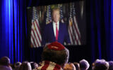 People listen as former president Donald Trump speaks remotely to an annual leadership meeting of the Republican Jewish Coalition, November 19, 2022, in Las Vegas. (AP Photo/John Locher)