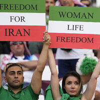 Iranian soccer fans hold up signs reading Woman Life Freedom and Freedom For Iran, prior to the World Cup group B soccer match between England and Iran at the Khalifa International Stadium in in Doha, Qatar, Nov. 21, 2022. (AP Photo/Alessandra Tarantino)
