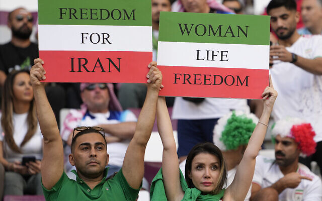 Iranian soccer fans hold up signs reading Woman Life Freedom and Freedom For Iran, prior to the World Cup group B soccer match between England and Iran at the Khalifa International Stadium in in Doha, Qatar, Nov. 21, 2022. (AP Photo/Alessandra Tarantino)