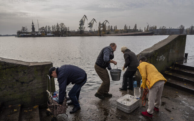 Residents of the recently liberated city of Kherson collect water from the Dnipro river bank, near the frontline, southern Ukraine, November 21, 2022. (Bernat Armangue/AP)