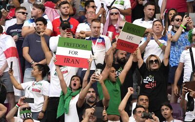 Iranian soccer fans hold up signs reading Woman Life Freedom and Freedom For Iran, prior to the World Cup group B soccer match between England and Iran at the Khalifa International Stadium in in Doha, Qatar, November 21, 2022. (Alessandra Tarantino/AP)