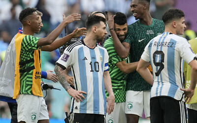 Argentina's Lionel Messi standing beside Saudi Arabia's players celebrating after winning the World Cup group C soccer match between Argentina and Saudi Arabia at the Lusail Stadium in Lusail, Qatar, November 22, 2022. (AP Photo/Natacha Pisarenko)