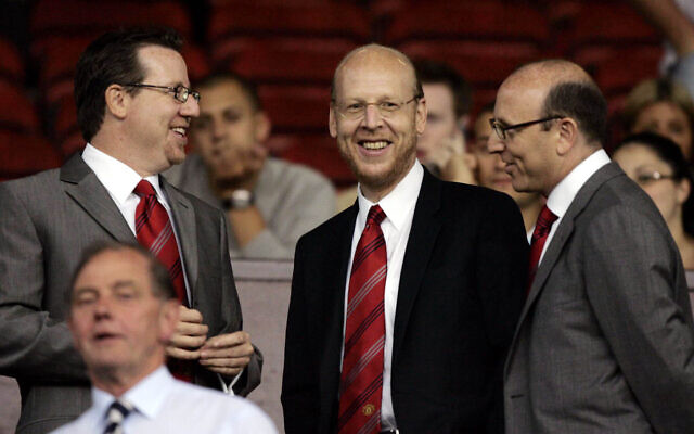 Manchester United board members Bryan Glazer, left, Avi Glazer, center, and Joel Glazer take their seats in the stands before their side's Champions League third qualifying round first leg soccer match against Debrecen at Old Trafford Stadium, Manchester, England, on Aug. 9, 2005. (AP/Jon Super, File)