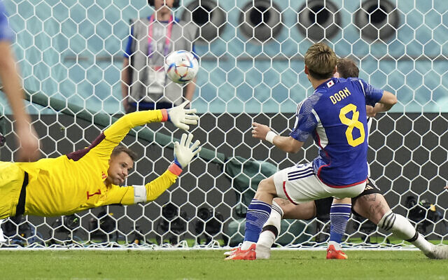 Japan's Ritsu Doan scores his side's first goal against Germany's goalkeeper Manuel Neuer, left, during the World Cup match between Germany and Japan, at the Khalifa International Stadium in Doha, Qatar, November 23, 2022. (AP Photo/Matthias Schrader)