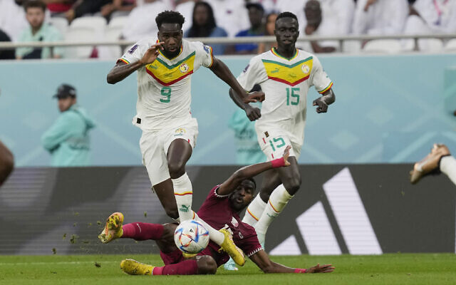 Senegal's Boulaye Dia is tackled by Qatar's Ismail Mohamad during the World Cup group A soccer match between Qatar and Senegal, at the Al Thumama Stadium in Doha, Qatar, Friday, Nov. 25, 2022. (AP/Thanassis Stavrakis)