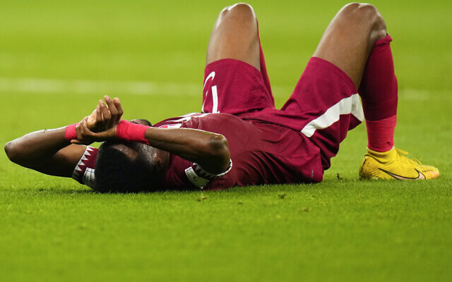 Qatar's Ismail Mohamad lies after his side's 1-3 lost against Senegal during a World Cup group A soccer match at the Al Thumama Stadium in Doha, Qatar, Friday, Nov. 25, 2022. (AP/Petr Josek)