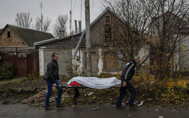 City workers collect the body of a man in Kherson, southern Ukraine, Friday, Nov. 25, 2022. The man died during a Russian attack the day before.  (AP/Bernat Armangue)
