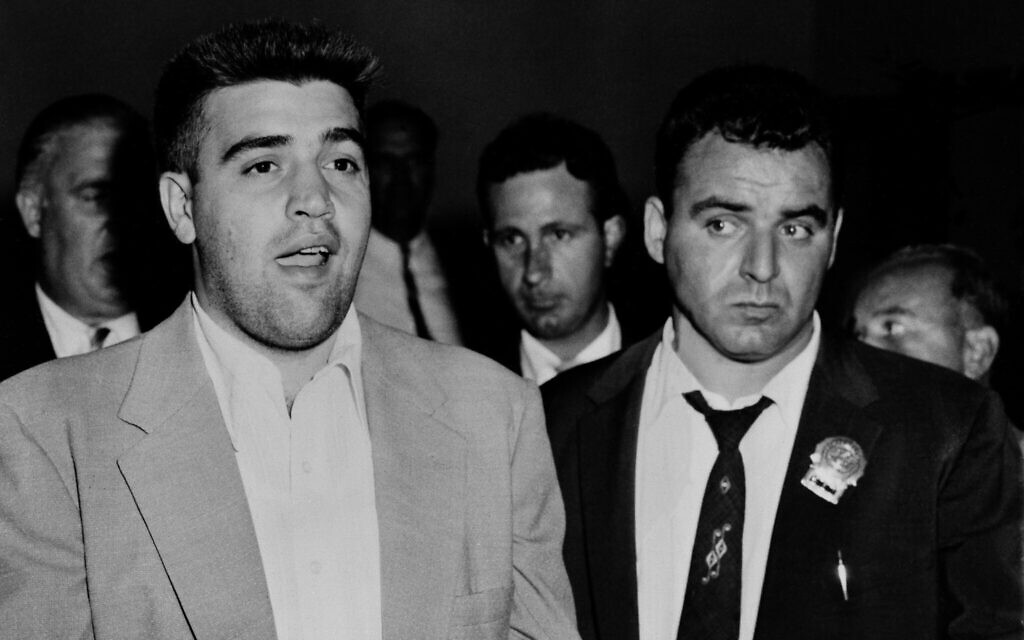 Vincent L. 'The Chin' Gigante, left, is booked at the West 54th Street police station in New York City, August 19, 1957, in connection with a bungled assassination attempt on racketeer Frank Costello on May 2 of that year. (AP Photo/Matty Zimmerman)