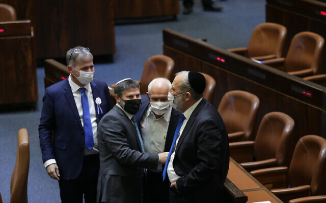 Bezalel Smotrich (second from left) talks to Aryeh Deri (right) at the Knesset in Jerusalem, April 6, 2021. (Alex Kolomoisky/POOL)