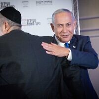 Head of the Likud party Benjamin Netanyahu, right, with Shas chair Aryeh Deri at a conference in Jerusalem on September 12, 2022. (Yonatan Sindel/Flash90)