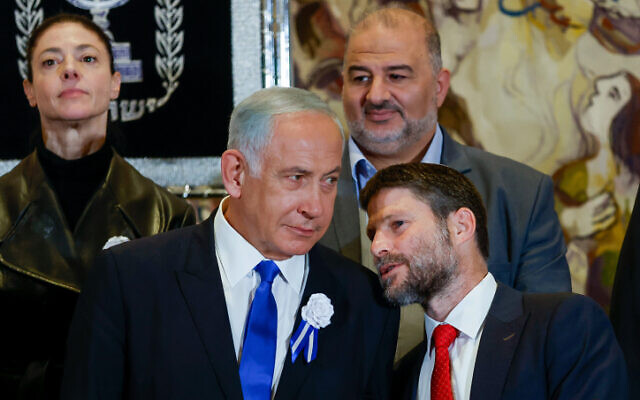 Likud leader MK Benjamin Netanyahu (left) speaks with Religious Zionist party head MK Bezalel Smotrich at the swearing-in ceremony of the 25th Knesset in Jerusalem, November 15, 2022. (Olivier Fitoussi/Flash90)
