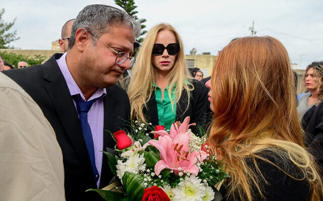 Head of the Otzma Yehudit party MK Itamar Ben Gvir, left, speaks with Lena Volkov, widow of Yuri who was stabbed to death during a road rage incident, seen at the Holon cemetery on November 27, 2022. (Avshalom Sassoni/Flash90)