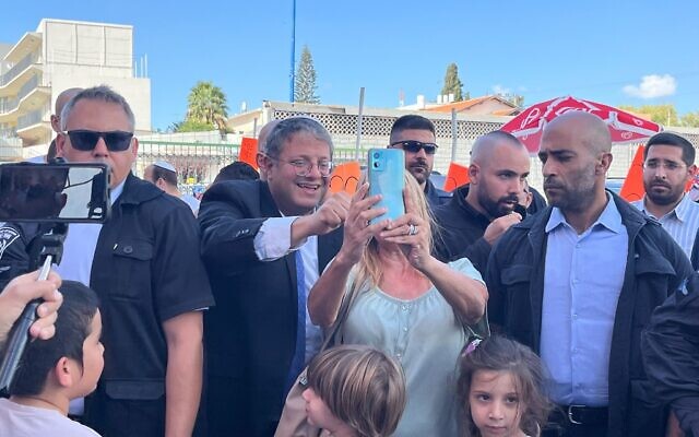 Itamar Ben Gvir poses for selfies with people as he campaigns in Sderot on election day on November 1, 2022 (Jacob Magid/Times of Israel)