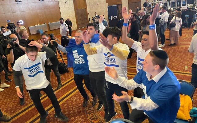 Likud activists celebrate after exit polls show a narrow majority for the right-religious bloc led by opposition chief Benjamin Netanyahu, November 1, 2022. (Carrie Keller-Lynn/Times of Israel)
