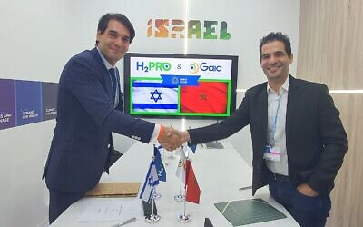 Moundir Zniber of Gaia Energy (left) and Talmon Marco of H2Pro shake hands on an agreement at the Israel Pavilion at the UN COP27 climate conference in Sharm el-Sheikh, Egypt, on November 8, 2022. (Courtesy, H2Pro)