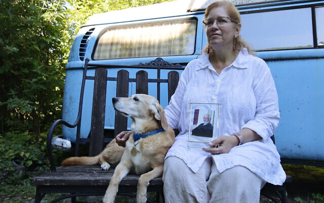 Giuliana Schnitzler sits with her dog Lucy while displaying an image of her father, Peter Schnitzler, at her home in Vienna, Austria, on June 23, 2022. Her father was taken out of Vienna to the United States by his family at just under 2 years old in late 1938. (Raquel G. Frohlich)