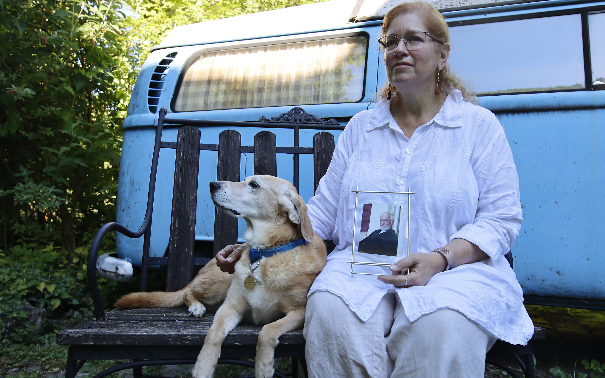 Giuliana Schnitzler sits with her dog Lucy while displaying an image of her father, Peter Schnitzler, at her home in Vienna, Austria, on June 23, 2022. Her father was taken out of Vienna to the United States by his family at just under 2 years old in late 1938. (Raquel G. Frohlich)