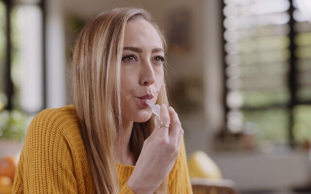 An image of a woman taking Salignostics' saliva-based pregnancy test. (Salignostics)