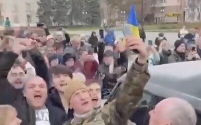 A screen capture of video from social media shows a Ukrainian soldier taking a selfie with cheering citizens in Kherson, after Russia retreated from the city, November 11, 2022. (Twitter screenshot, used in accordance with Clause 27a of the Copyright Law)