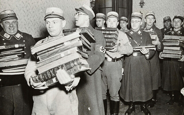 German Nazis carry Jewish books, presumably for burning, during Kristallnacht, most likely in the town of Fuerth, Germany on Nov. 10, 1938. (Yad Vashem via AP)