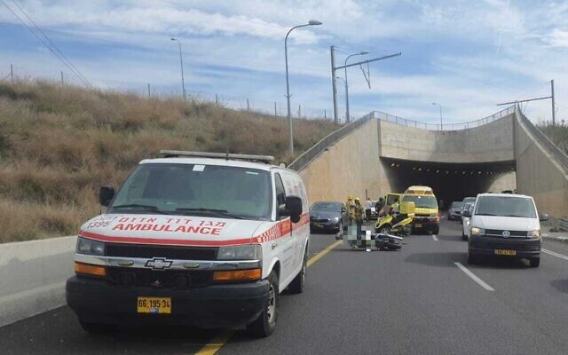Am ambulance is seen at the site of a collision between a motorcyclist and a private vehicle on Road 531 near Herzliya on November 27, 2022. (Magen David Adom)