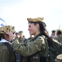 File: An officer in the Border Defense Corps places a beret on a soldier's head, in an undated photo published by the military. (Israel Defense Forces)