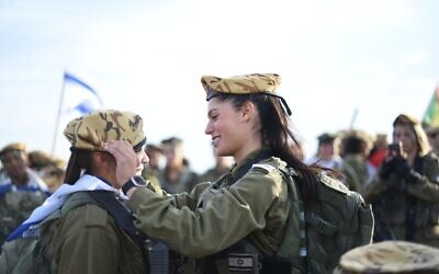 File: An officer in the Border Defense Corps places a beret on a soldier's head, in an undated photo published by the military. (Israel Defense Forces)