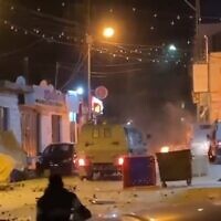 A screenshot from a video showing Palestinians hurling stones at Israeli military vehicles in Beit Ummar, near the West Bank city of Hebron. (WANBreaking on Twitter, used in accordance with Clause 27a of the Copyright Law)
