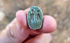 A scarab seal found in Azor in November 2022, showing a seated figure on the right and a standing figure with a raised arm on the left, possibly symbolizing an ancient Egyptian pharaoh imparting authority on a local Canaanite ruler. (Gilad Stern, Israel Antiquities Authority)