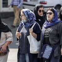 In this file photo from September 26, 2022, women wearing head coverings walk along a street in the center of Iran's capital Tehran. (Atta Kenare/AFP)