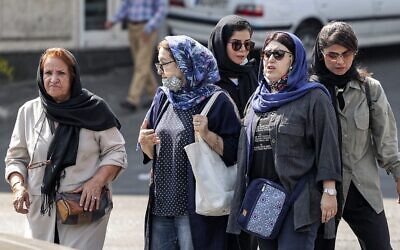 In this file photo from September 26, 2022, women wearing head coverings walk along a street in the center of Iran's capital Tehran. (Atta Kenare/AFP)
