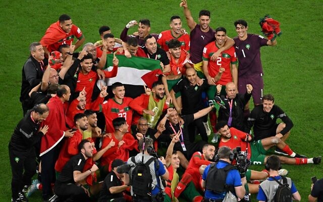 Morocco’s players celebrate with a Palestinian flag at the end of the Qatar 2022 World Cup round of 16 soccer match between Morocco and Spain at the Education City Stadium in Al-Rayyan, west of Doha on December 6, 2022. (Glyn Kirk/AFP)