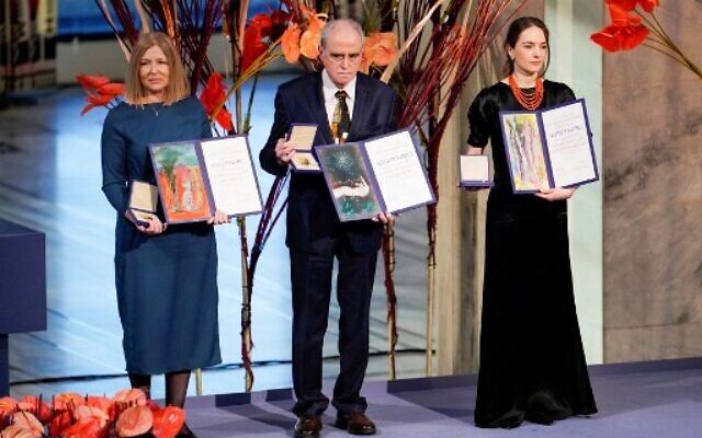 Natalia Pinchuk (L) on behalf of her husband Nobel Peace Prize 2022 winner, jailed Belarusian activist Ales Bialiatski, Memorial chairman Yan Rachinsky (C) on behalf of Russian human rights organisation Memorial, and Head of the Ukrainian Center for Civil Liberties (CCL) Oleksandra Matviichuk pose with their Nobel Peace Prize certificates and medals during the 2022 Nobel Peace Prize award ceremony at the City Hall in Oslo, Norway, on December 10, 2022. (Rodrigo Freitas/NTB/AFP)