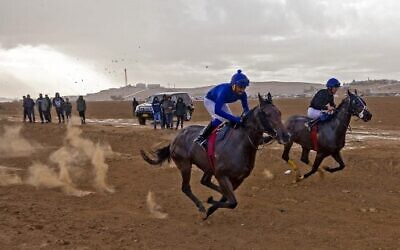 Jockeys compete in a weekly horse-racing competition at a field near the Bedouin village of Abu Tlal in southern Israel near Beersheva on November 25, 2022. (Menahem Kahana/AFP)