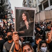 A protester holds a portrait of Mahsa Amini during a demonstration in support of Amini, a young Iranian woman who died after being arrested in Tehran by the Islamic Republic's morality police, on Istiklal avenue in Istanbul on September 20, 2022. (Ozan Kose/AFP)