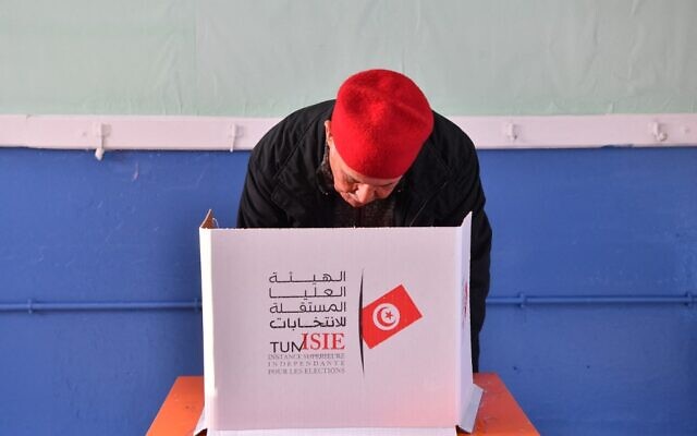 A Tunisian voter casts his ballot at a polling station in Mnihla district outside Tunis on December 17, 2022, during the parliamentary election. (FETHI BELAID / AFP)