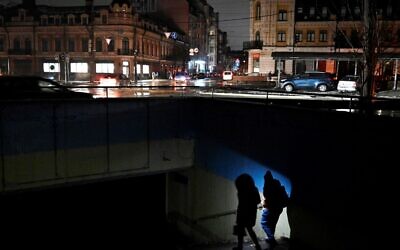 People use a flashlight as they enter an underground passage  during a blackout following Russian strikes on the power infrastructure in Kyiv on December 17, 2022, amid the Russian invasion of Ukraine. (Sergei CHUZAVKOV / AFP)