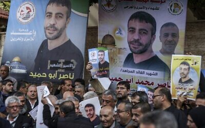 People gather with photos of Palestinian Nasser Abu Hmeid for a protest outside the International Committee of the Red Cross (ICRC) mission headquarters in Gaza City on December 20, 2022.  (Mahmud HAMS / AFP)