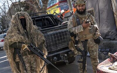 Taliban security personnel stand guard along a road in Kabul on December 21, 2022. (Wakil KOHSAR / AFP)