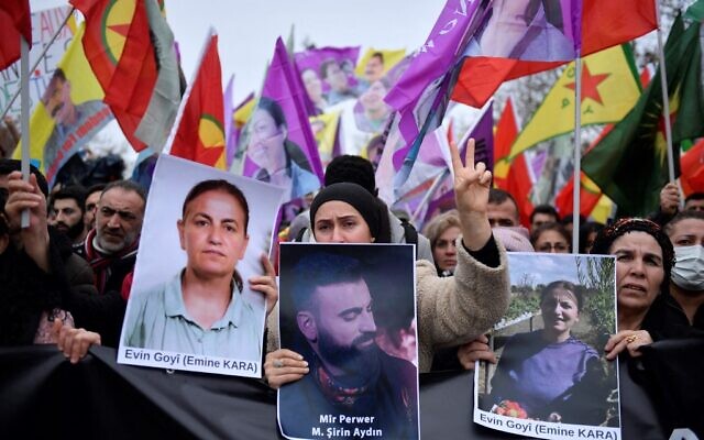 Supporters and members of the Kurdish community hold portraits of victims Emine Kara and Mir Perwer during a demonstration a day after a gunman opened fire at a Kurdish cultural centre killing three people, at The Place de la Republique in Paris on December 24, 2022. (Photo by JULIEN DE ROSA / AFP)