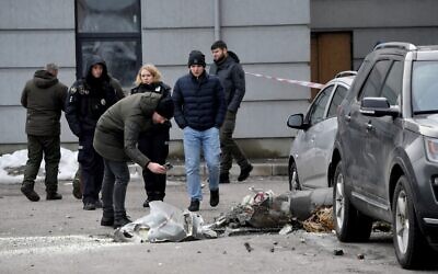 Police experts examine remains of a downed missile which fell on vehicles parked at a multi-story residential building in Kyiv on December 29, 2022, during Russian missiles strike to Ukraine (Sergei SUPINSKY / AFP)