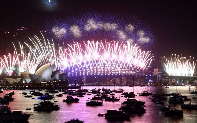 New Year's Eve fireworks light up the sky over the Sydney Opera House (L) and Harbour Bridge during the fireworks display in Sydney on January 1, 2023. (David Gray/AFP)